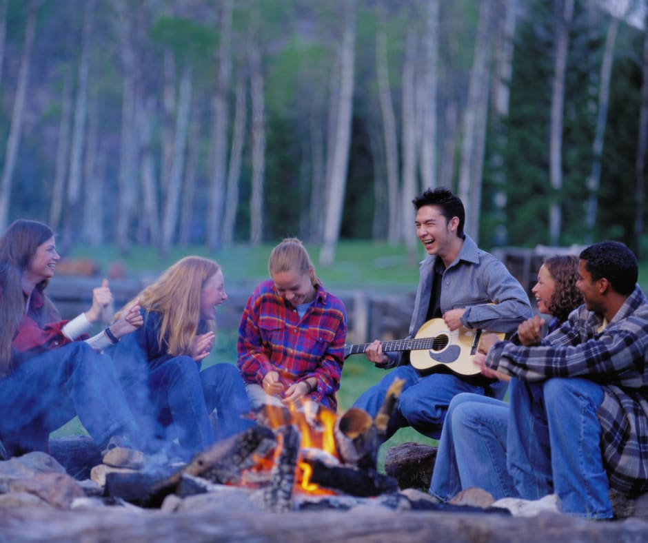young people sat around a campfire
